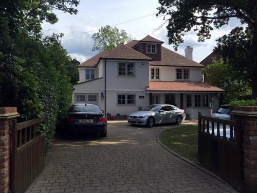 construction company in Epsom and Surrey detached white house with two cars and driveway